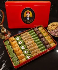 Red Metal Hafız Mustafa box with 8 different pistachio baklava flanked a plate of Gaziantep pistachios and an copper coloured Ottoman half moon.