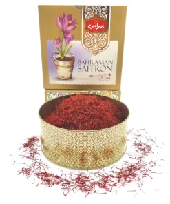 Bahraman Saffron with large metal jar filled with Top Negin Saffron and some Saffron sprinkled around.
