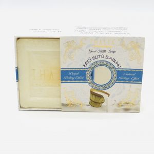 Half open beige, golden box with blue line showing a square white bar of Organic Goat Milk Soap.