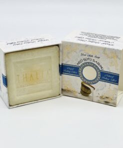 Open beige, golden box with blue line showing a square white bar of Organic Goat Milk Soap.