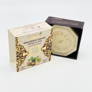 Open box with Macadamia nuts showing a hexagonal Organic Macadamia Soap.