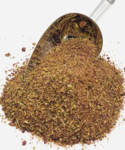 Pile of Salad Spice Mix with a silver coloured spice spoon stuck in the pile