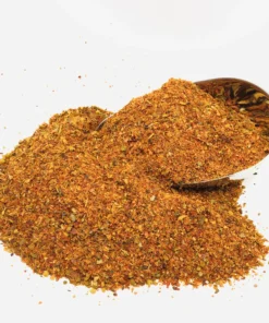 Pile of BBQ (Ottoman) Spice Mix with a large metal spice spoon on a white background.