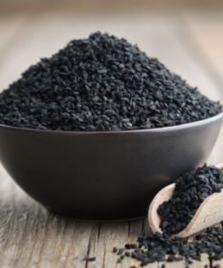Bowl with a pile of Black Cumin Seeds, with a wooden spice spoon on the side filled with Black Cumin Seeds