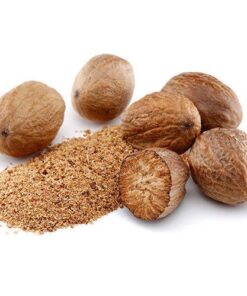 Five whole nutmegs next to a half grated Nutmeg with Grated Nutmeg next to it.