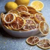 Naturally Dried Lemon slices in a bowl with whole lemons in the background