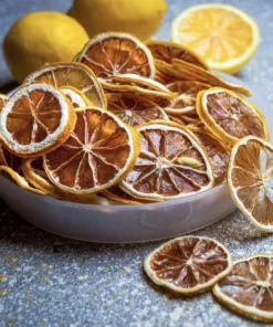Naturally Dried Lemon slices in a bowl with whole lemons in the background