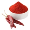 White bowl with ground hot paprika with three dried cilli peppers on the side